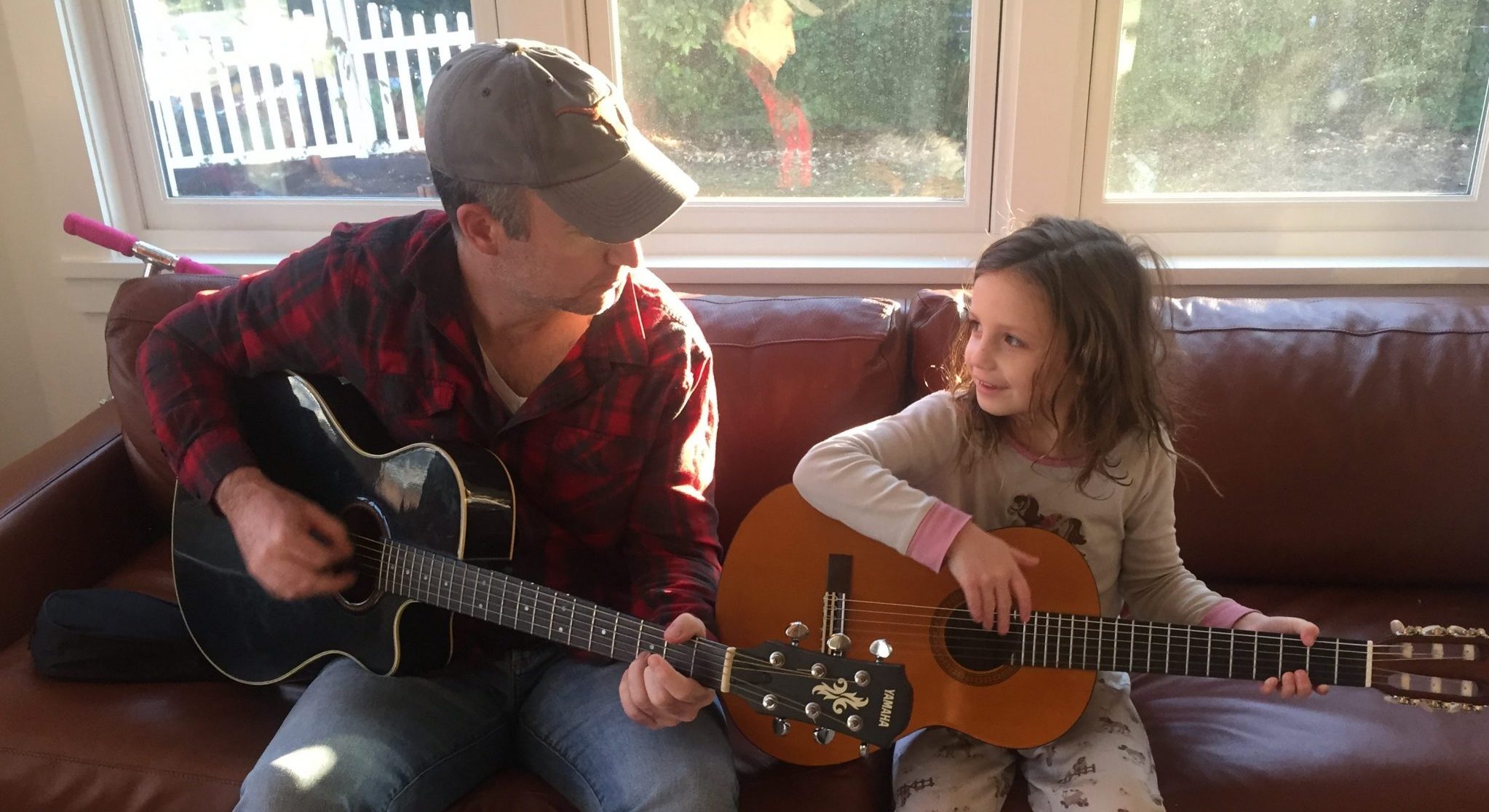 Shawn Brimley teaching Claire to play the guitar