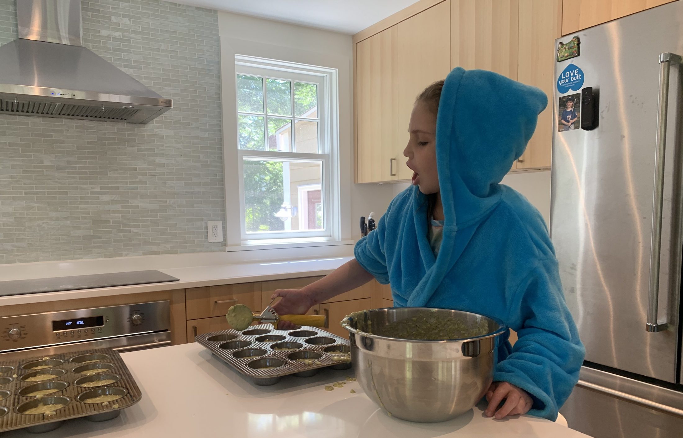 Claire Brimley daughter of DC widow blog writer Marjorie Brimley makes muffins in their kitchen in a blue robe in Washington