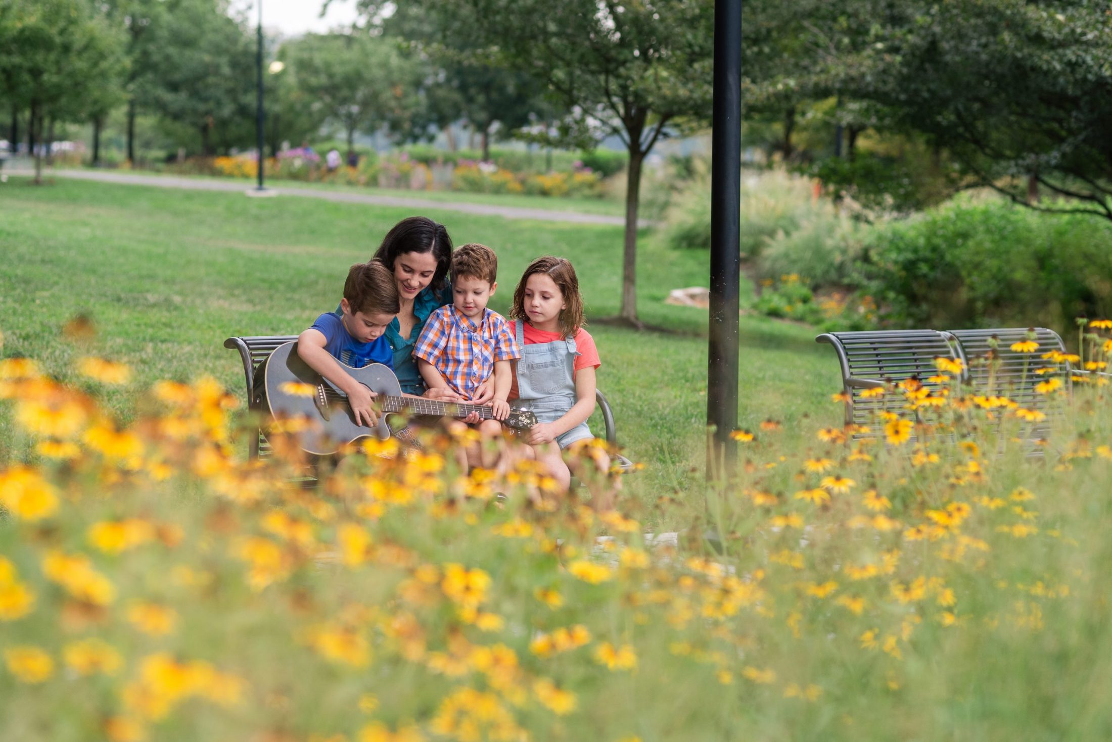 DC widow blog writer Marjorie Brimley on bench with children and flowers